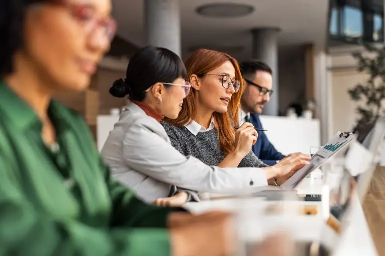 Diverse Team Collaborating During Professional Office Meeting With Documents