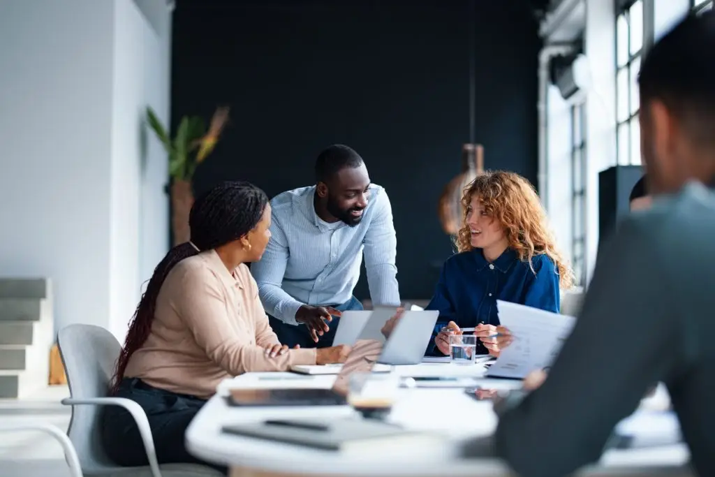 A group of colleagues working together in a contemporary office environment, focused on collaboration and teamwork to achieve professional goals. This setting embodies a productive and dynamic workplace atmosphere.