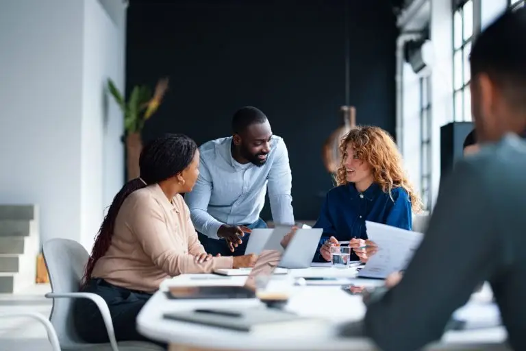 A group of colleagues working together in a contemporary office environment, focused on collaboration and teamwork to achieve professional goals. This setting embodies a productive and dynamic workplace atmosphere.